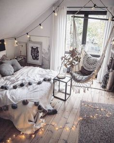 a bedroom with a hammock hanging from the ceiling and string lights strung across the bed