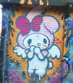 graffiti on the side of a building with a hello kitty face