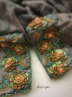 a close up of a scarf with flowers on it and green beads around the edges