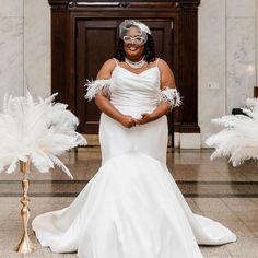 a woman in a white dress and some feathers