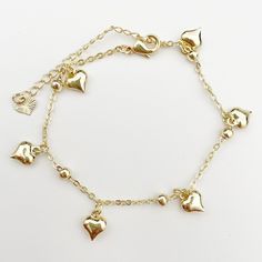 Anklet with 6 small heart charms.  Extension chain to adjust to the desired size.  14k gold plated chain. Measurement: 19.5 cm/ 7.67'' inch approx,  with 5 cm/ 1.9'' inch extension chain. Adjustable Gold Heart Charm Bracelet, Elegant Adjustable Anklets With Heart Charm, Adjustable Heart Metal Anklets, Adjustable Heart-shaped Metal Anklet, Adjustable Heart-shaped Dainty Anklets, Gold Adjustable Dangle Anklets, Gold Dangle Anklets With Adjustable Fit, Elegant Gold Anklets With Heart Charm, Elegant Gold Chain Bracelet With Dangling Charms