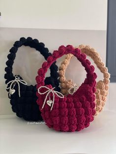 three crocheted baskets sitting on top of a white counter next to each other