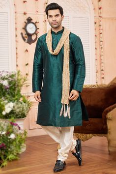 Create an extraordinary style statement by wearing this readymade teal green art silk men's kurta churidar and woven zari dark beige silk dupatta. It also features a Chinese collar neck and full sleeves. Accompanied by a beige-colored art silk bottom. This kurta churidar can be customized up to a maximum size of 46 inches. Slight color variation may occur due to photographic reasons. Velvet Suit Design, Anarkali Suits Bollywood, Frock Style, Green Plain, Bollywood Dress, Kurta Men, Men's Kurta, Chinese Collar, Orange Saree