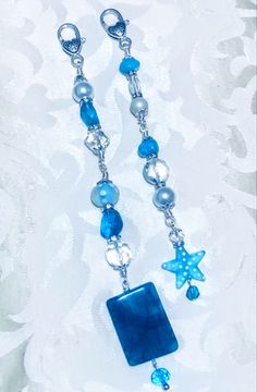 a blue and white beaded necklace with starfish charms hanging from it's sides