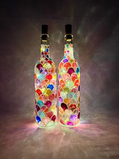 two bottles with different colored glass hearts on them