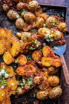 some fried food is on a tray with a spatula and wooden utensils