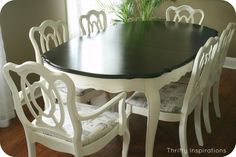 a dining room table with white chairs and a potted plant in the window sill