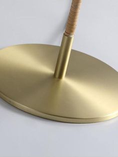 a gold umbrella with a wooden stick sticking out of it's center hole on a white surface