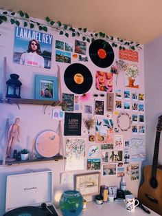 there is a wall covered with pictures and vinyl records on the wall next to a record player