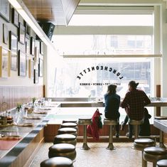 two people sitting at a table in a restaurant with lots of counter space and stools