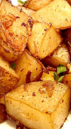 cooked potatoes on a white plate with herbs