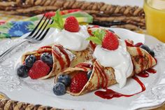 pancakes with fruit and whipped cream are on a plate