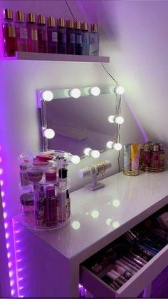 a white vanity with lights and cosmetics on it