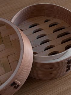 two wooden baskets sitting on top of a wooden table next to each other with holes in them