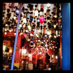 a room filled with lots of lamps hanging from the ceiling