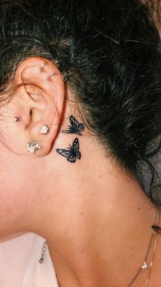 a woman with butterfly tattoos on her ear