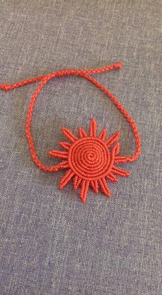 an orange string is attached to a piece of fabric with a sun motif on it