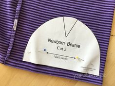 a purple and white t - shirt with the name newborn beanie cut 2 on it