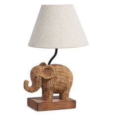 an elephant lamp on a wooden base with a white lampshade over it's head