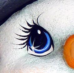 a close up of an orange and white bird's eye with long eyelashes on it