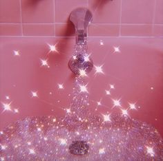 a pink bathroom with stars on the wall and a sink faucet in it