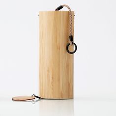 a wooden container with a black ring on the handle and a cord attached to it