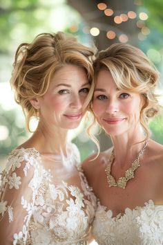 two beautiful women standing next to each other in front of a tree filled with lights