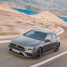 a silver mercedes cla driving down the road