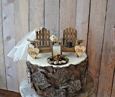 a wedding cake with two chairs on top of it and the word mr and mrs written in wood