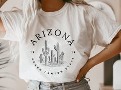 Arizona Tshirt Women, Arizona Shirt, Arizona Gifts for Women, Arizona T Shirt, Arizona Cactus Shirt, Arizona T-Shirt * Design is high-quality screen printed. * Unisex sizing - if you want it oversized, size up! * Please see the size guide for measurements! * Super soft t-shirt made with either 100% cotton or mix of cotton/polyester (depending on the shirt color). If you have any questions, feel free to message me! Shop Homepage: https://www.etsy.com/shop/peachleafstore/ If you have any issues wi Arizona T Shirt Designs, Arizona Tshirt, Sorority Tshirt Designs, Arizona Tee, Arizona Gifts, Cactus Tshirt, Arizona Cactus, Cactus Shirt, Merch Design