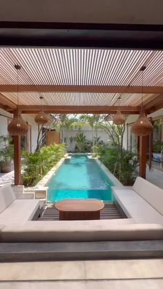 an outdoor living area with couches and a swimming pool