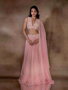 Soft pink flowy lehenga with a tiered hem featuring an ivory pearl drop embellished waistband, paired with a plunge neck tie up blouse hand embellished with ivory florals. Paired with a net dupatta hand embellished with ivory pearls, mixed materials & glass beaded tassles.From Shloka Khialani's Winter Sun collection.DELIVERY TIMEPlease allow 6-8 weeks for your outfit to arrive.FABRIC DETAILSGeorgette, Net, CrepeProfessional cleaning only. Pink Hand Embellished Organza Choli, Pink Hand Embellished Organza Anarkali Set, Pink Hand Embellished Georgette Dupatta, Hand Embellished Pink Anarkali Set For Wedding, Pink Hand Embellished Anarkali Set For Wedding, Hand Embellished Pink Georgette Dupatta, V-neck Wedding Choli With Mirror Work, V-neck Lehenga With Mirror Work For Wedding, Pink Hand Embellished Sharara For Diwali