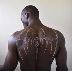 the back of a man's body with white lines drawn on his chest and arms