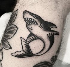 a man's arm with a shark tattoo on it