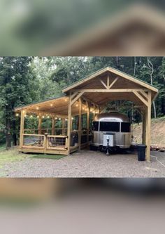 a trailer parked in front of a wooden structure with lights on it's sides