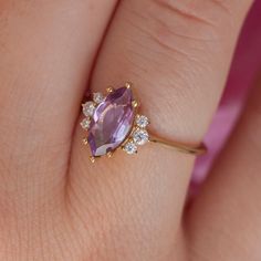 A ring that is fit for a queen, our Sophia Amethyst ring sparkles with a stunning 1.1-carat marquise cut Amethyst. Made with impeccable craftsmanship to last, the Sophia ring is the perfect choice for an engagement or wedding ring you will treasure for a lifetime. Details: Center stone Gemstone: Amethyst Stone Shape: Marquise Measurements: approx. 10x5mm Total carat weight: 1.1 carat Side stones Gemstone: Moissanite Shape: Round Measurements: approx. 2mm, 1.5mm Band measurements: approx. 1.8mm w Round Solitaire Rings, Planet Ring, Black Spinel Ring, Opal Solitaire Ring, Moss Agate Ring, London Blue Topaz Ring, Rose Quartz Ring, Sparkling Rings, Jewelry Model