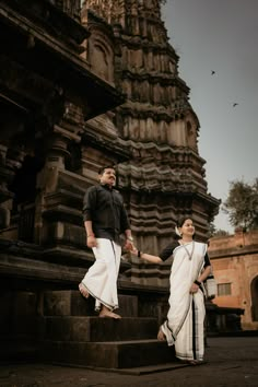 a man and woman walking up some steps