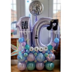 the number ten balloon is displayed in front of a disco ball and some other decorations