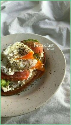 an egg and tomato sandwich is on a white plate with the words breakfast toast above it