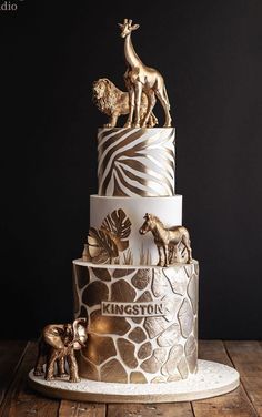 a three tiered cake decorated with animals and giraffes