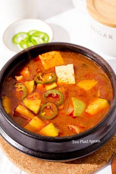 a bowl filled with soup and vegetables on top of a table