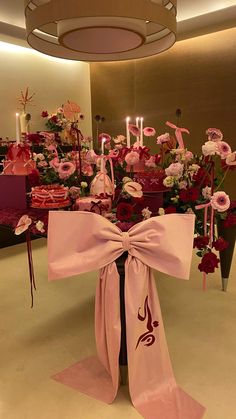 a table with flowers and candles on it in front of a large centerpiece that says happy birthday