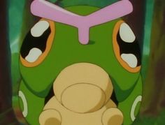 a green and pink backpack sitting in front of a tree with its eyes closed,