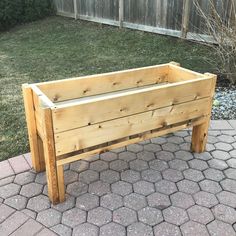 a wooden planter sitting on top of a brick walkway