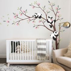 a baby's room with a panda bear tree mural