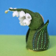 a close up of a stuffed animal with flowers on it's head and tail