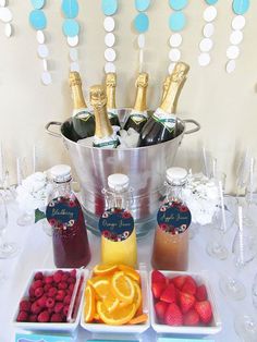 a table topped with bottles of champagne and fruit