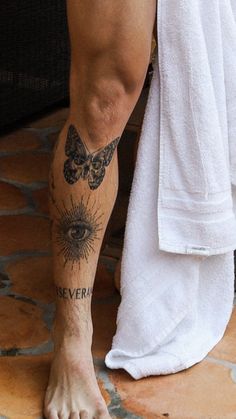 a close up of a person's foot with tattoos on it and a towel