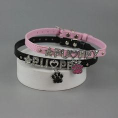 three different bracelets with charms on top of each other, one has a dog's paw and the other has a heart