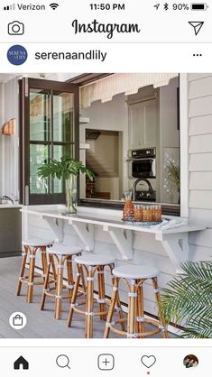 an outdoor bar with stools and a potted plant on the counter next to it